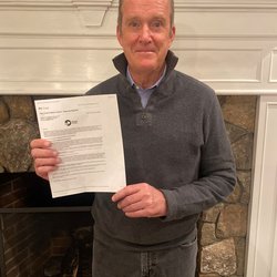 Bryan Lynch holds his invitation for peace corps service