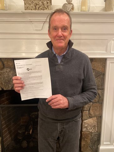 Bryan Lynch holds his invitation for peace corps service