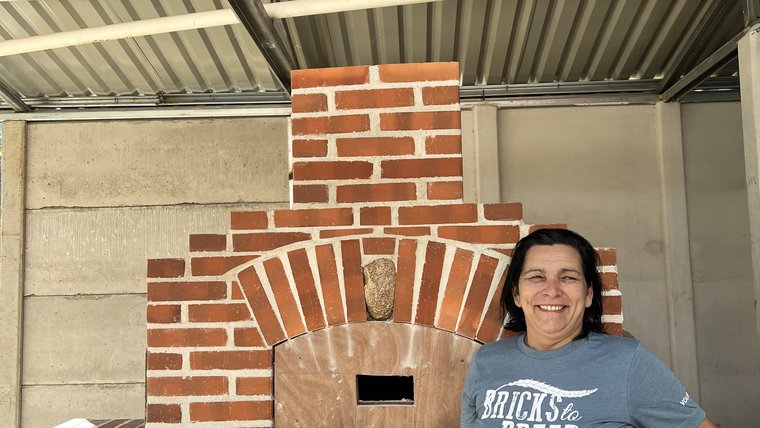 Women's group president Blanca stands proudly with the brand-new oven built in Costa Rica with the support of a nonprofit based in Minnesota.