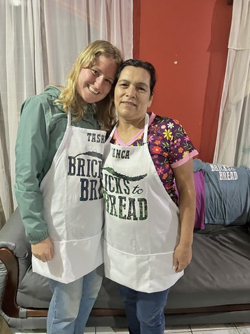 Tasha and Blanca M., the women's group president and Tasha’s host mother, wear their new Bricks to Bread aprons.