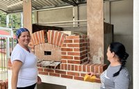 Two members of a Costa Rican women's group work on constructing a new oven with the support of a nonprofit based in Minnesota.