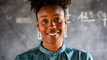 Portrait of Brina in front of a chalk board