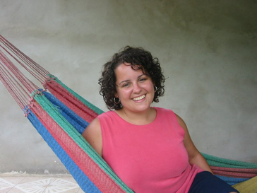 A female volunteer smiles in her hammock