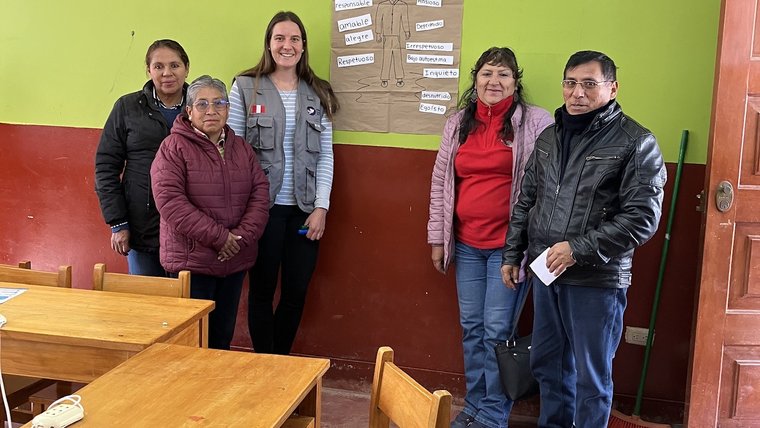 Volunteer standing with four local teachers.
