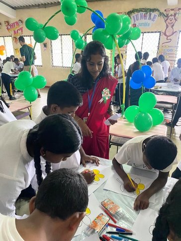 Sathya oversees students preparing decorations for the event.