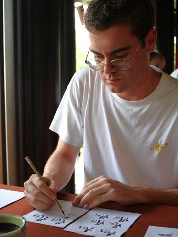 Matthew tries his hand at traditional calligraphy in Viet Nam.