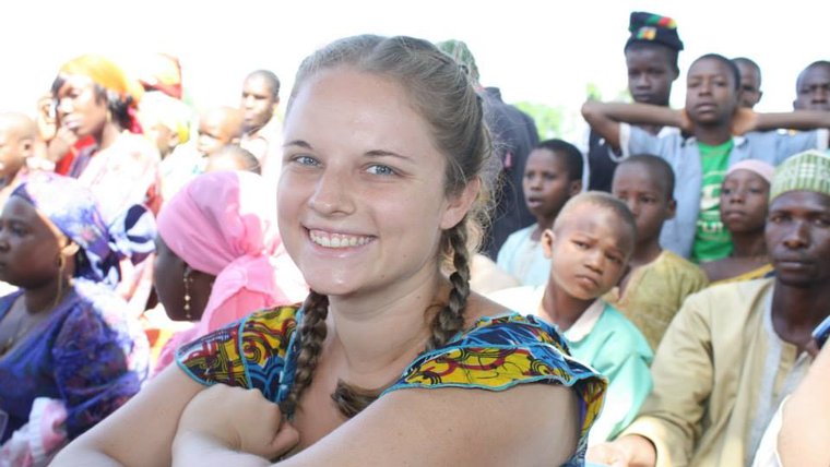 A Peace Corps Volunteer watches a celebration in her community in Cameroon.