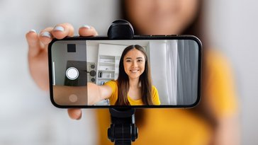 An image of a teenage girl holding up a cellphone.