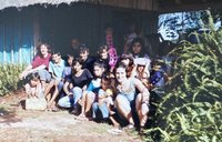 Chris Lins sits with community members on the steps of a home in Paraguay.