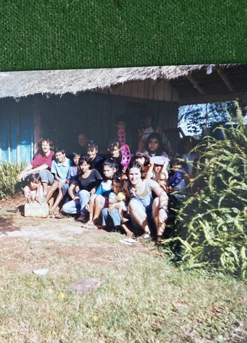 Chris Lins sits with community members on the steps of a home in Paraguay.