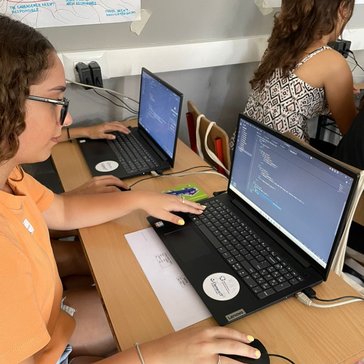 A young girl practices software coding on a laptop