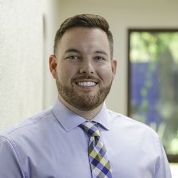 A head shot of Travis Craddock smiling at the camera