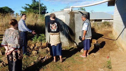 Rotary Club representative inspects tank with PCV couple and their principal