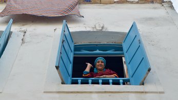 Woman in Morocco Opens a Window