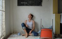 Returned Volunteer Chase sitting under a sign that reads inspired