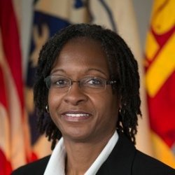 A Black woman smiles for a professional head shot.