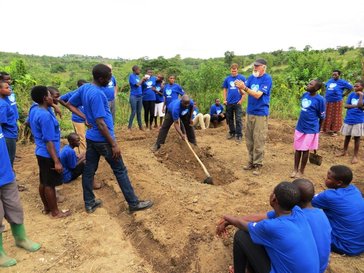 Peace Corps Volunteers David McHolland teaching permagarden digging to the Blue House girls_edited.jpg