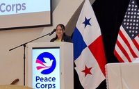 Dena, a female Peace Corps Volunteer in Panama, stands behind a Peace Corps podium