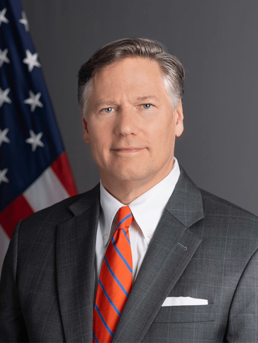 A man in a suit with a flag