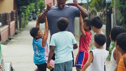1.	A Children, Youth, and Family Volunteer playing with children in his host community.