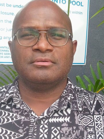 A headshot of a man not smiling in floral shirt