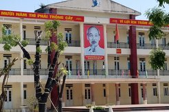 Portrait of Ho Chi Minh and banner hangs from the eaves of a Hanoi school.