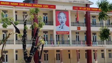 Portrait of Ho Chi Minh and banner hangs from the eaves of a Hanoi school.