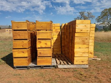 Large wooden stacks of beehives