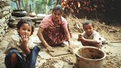 A Nepali mother and her children in the courtyard of their home.