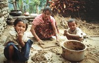 A Nepali mother and her children in the courtyard of their home.