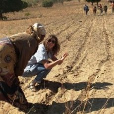 Peace Corps Volunteer Chelsea Rinnig works with a community member to make lines with a “ripper,” a tool that assists in the