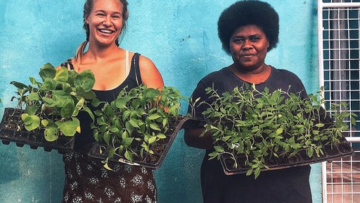 Two women holding plants