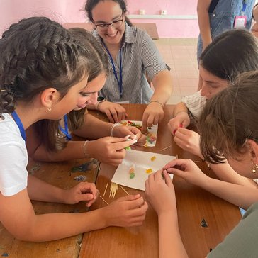 Five young women put gummy bears on toothpicks