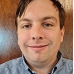 White male person with short black hair.