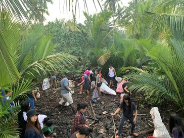 Group of students cleaning out the channel for fish pond