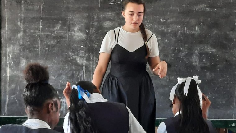 Volunteer in front of classroom.
