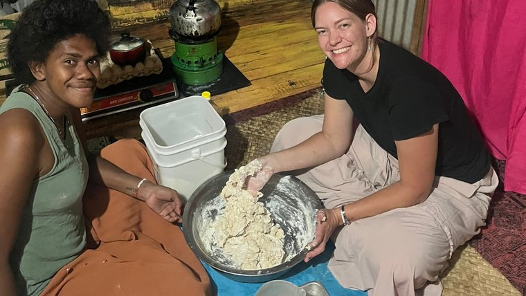 Volunteer cooking with her youth counterpart