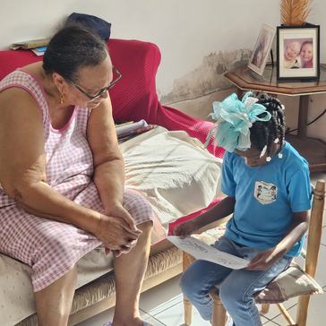 A child reads to a welcoming elder in Saint Lucia.