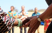 Two people shake hands. One is American and one is Malawian.