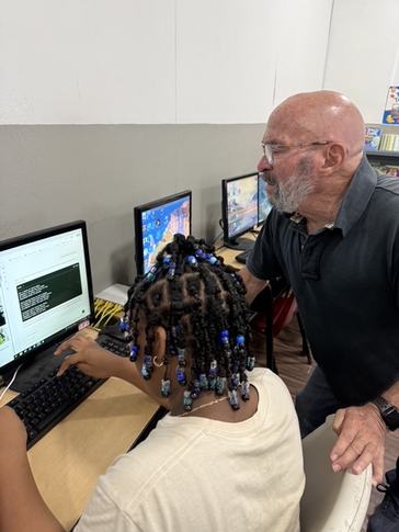 Arthur supports a student with digital literacy in Saint Lucia.