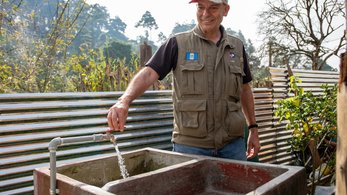 Peru PCV Luis turning on a faucet