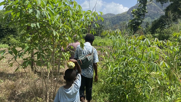 Wonde walking with a group of kids through foliage.