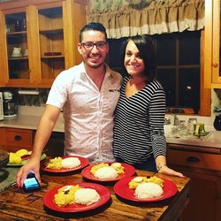 A Peruvian man and a white woman stand together by a table and smile