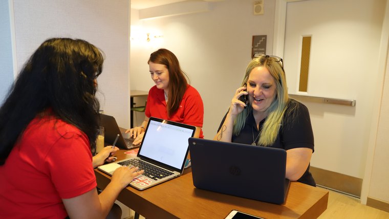 Three individuals sitting in front of their laptops