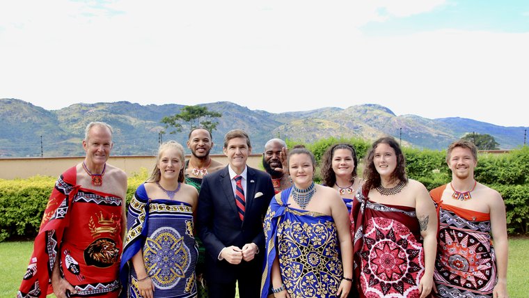 Group of volunteers posing with former Chargé D'Affaires during their swearing-in ceremony