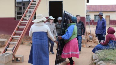 Women of the Community Lifting Solar Panel