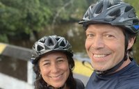 Ileana and Michael with bike helmets on a bridge