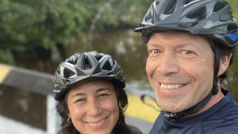 Ileana and Michael with bike helmets on a bridge
