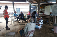 Initiating the Community Savings Group after a hard days work on the crops.