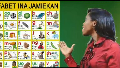 A woman shows the Jamaican alphabet